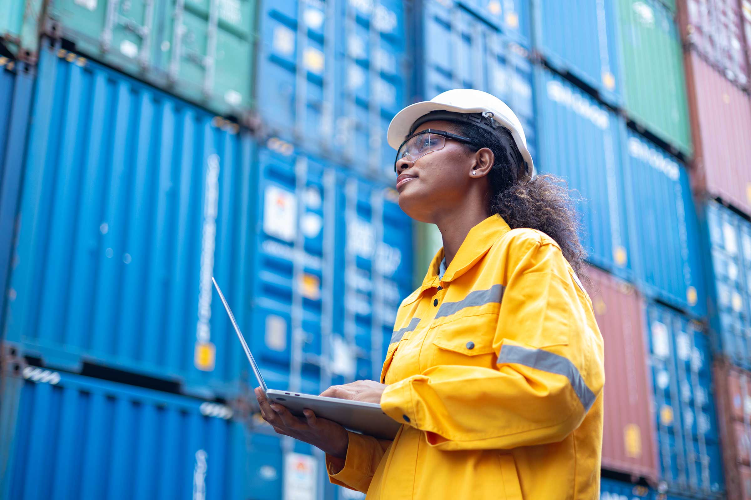 An engineer inspecting shipping containers at a dockyard