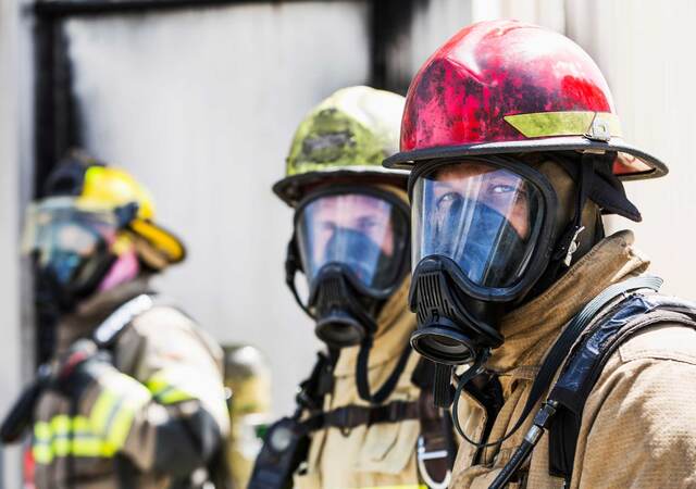 Three firefighters wearing protective equipment